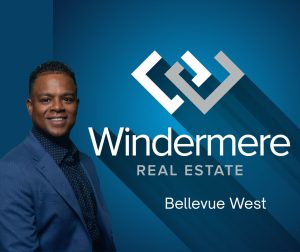 Corey Ruffin, real estate professional with Windermere Real Estate, smiling confidently in a business suit.